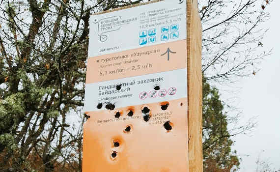 фотография обстрелянного информационного указателя на маршруте «Большая Севастопольская тропа». Кто-то потратил несколько десятков пуль, чтобы его испортить