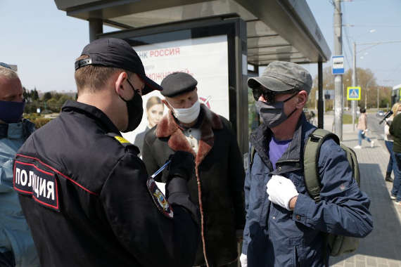 полицейский в Севастополе проверяет пропуска на право передвижения по городу у граждан