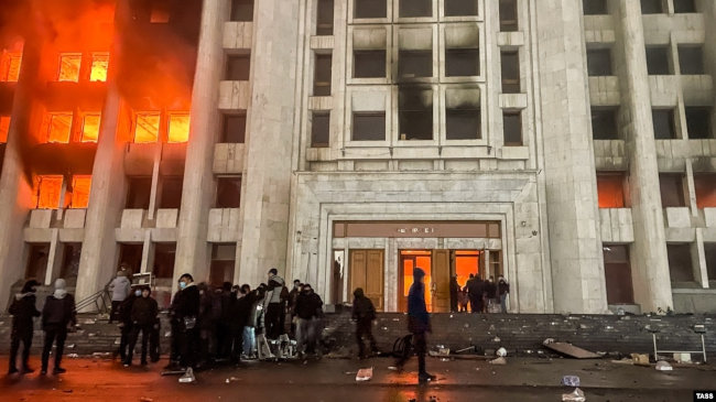 Протестующие возле горящего здания городской администрации. Казахстан, Алматы