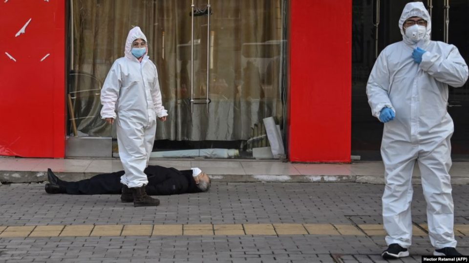 Медработники в защитных костюмах эвакуируют умершего на улице в Ухане