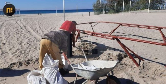 В Крыму местные жители в мешках выносят с пляжа песок