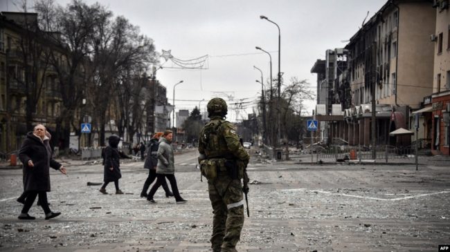 Российский военный на улице разрушенного Мариуполя,